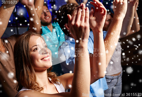 Image of smiling friends at concert in club