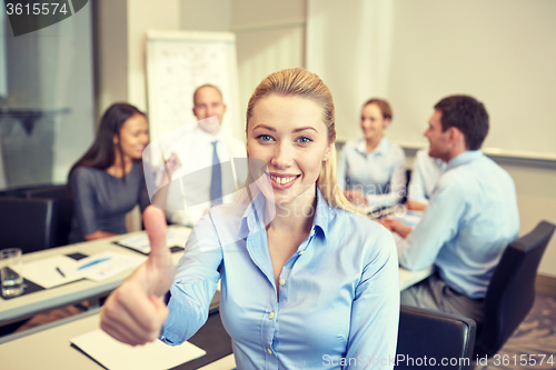 Image of group of smiling businesspeople meeting in office