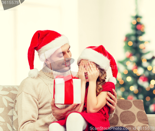 Image of smiling daughter waiting for a present from father