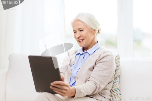 Image of happy senior woman with tablet pc at home