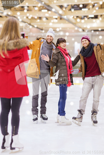 Image of happy friends taking photo on skating rink