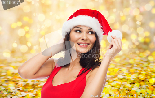 Image of beautiful woman in santa hat over golden lights