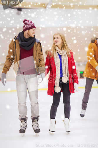 Image of happy couple holding hands on skating rink