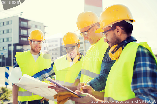 Image of group of builders with tablet pc and blueprint