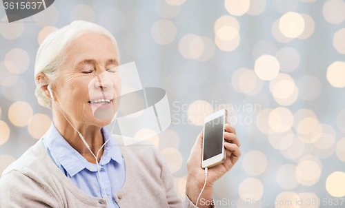 Image of senior woman with smartphone and earphones