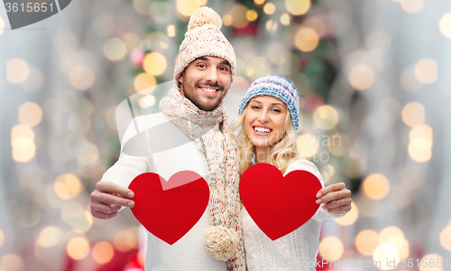 Image of smiling couple in winter clothes with red hearts