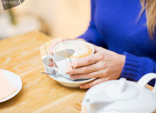 Image of close up of woman with coffee cup at cafe