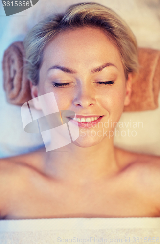 Image of close up of smiling young woman lying in spa