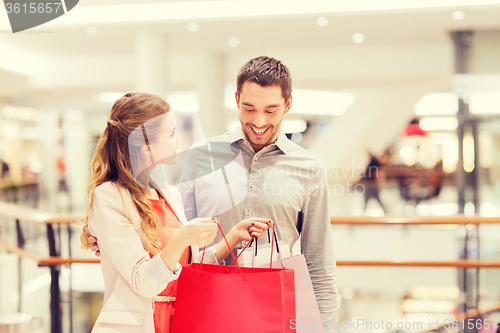 Image of happy young couple with shopping bags in mall
