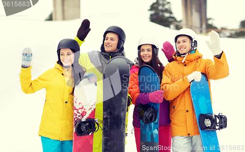 Image of happy friends in helmets with snowboards