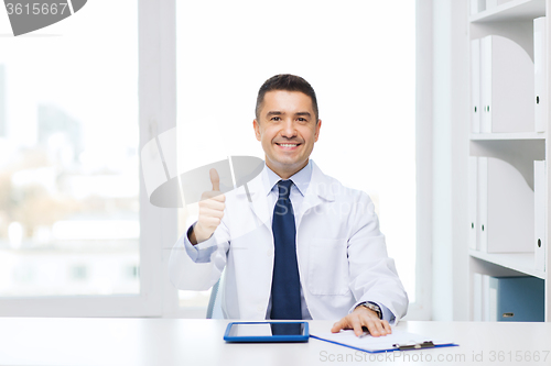 Image of smiling doctor with tablet pc showing thumbs up