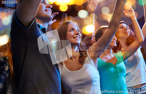 Image of smiling friends at concert in club