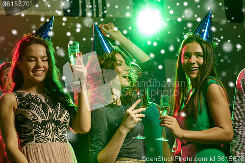 Image of smiling friends with glasses of champagne in club