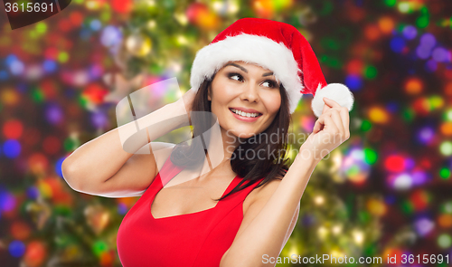 Image of beautiful woman in santa hat over christmas lights