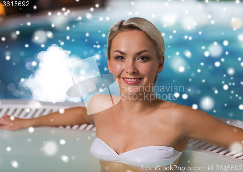 Image of happy woman sitting in jacuzzi at poolside