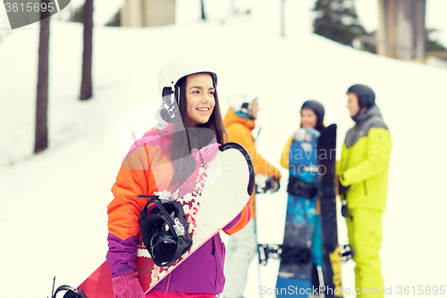 Image of happy friends in helmets with snowboards