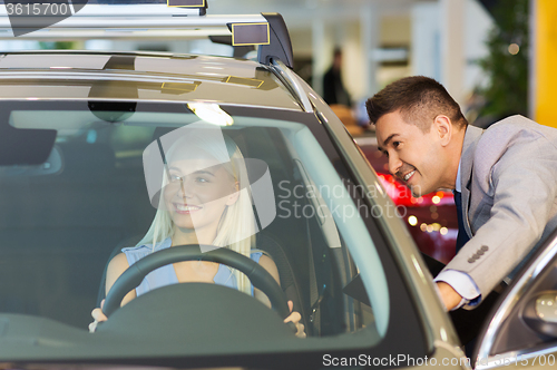 Image of happy woman with car dealer in auto show or salon