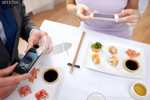 Image of close up of couple with smartphones at restaurant