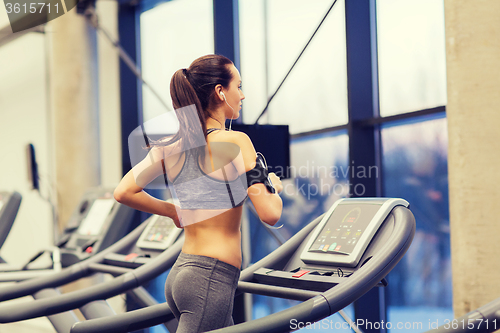 Image of woman with earphones exercising on treadmill