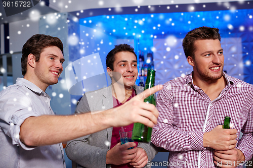 Image of group of male friends with beer in nightclub