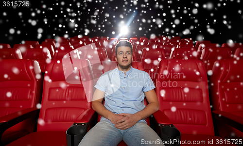 Image of happy young man watching movie in theater