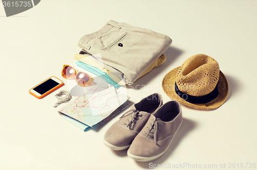 Image of close up of summer clothes and travel map on table