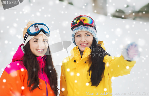 Image of happy girl friends in ski goggles outdoors