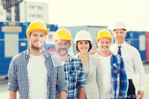 Image of group of smiling builders in hardhats outdoors