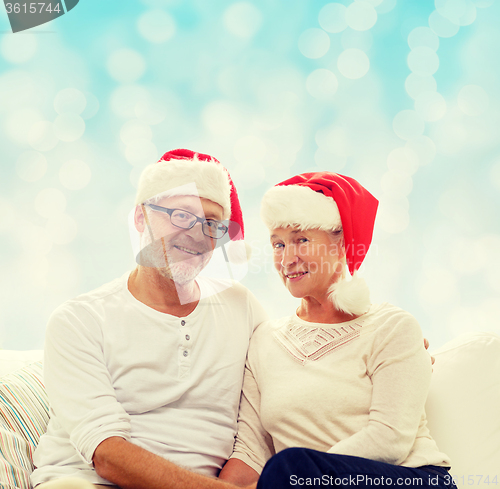 Image of happy senior couple in santa helper hats