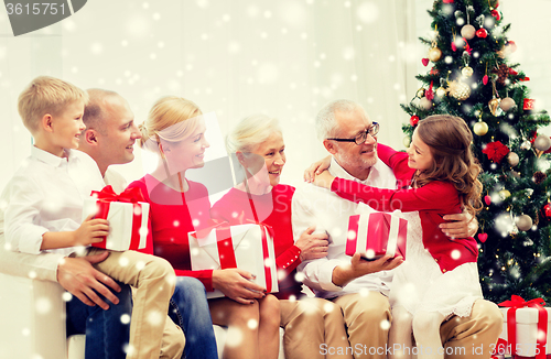 Image of smiling family with gifts at home