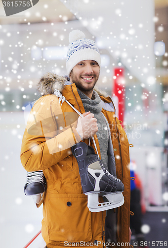 Image of happy young man with ice-skates on skating rink