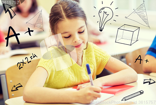 Image of group of school kids writing test in classroom