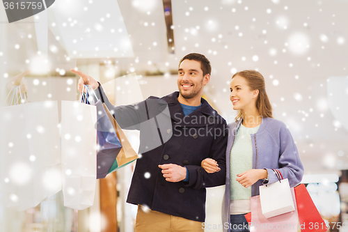 Image of happy young couple with shopping bags in mall