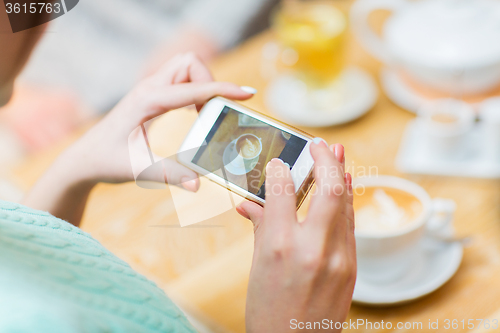 Image of close up of woman smartphone picturing coffee cup