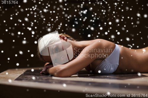 Image of young woman lying on hammam table in turkish bath