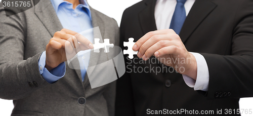 Image of businessman and businesswoman with puzzle pieces