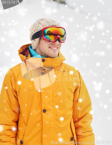 Image of happy young man in ski goggles outdoors