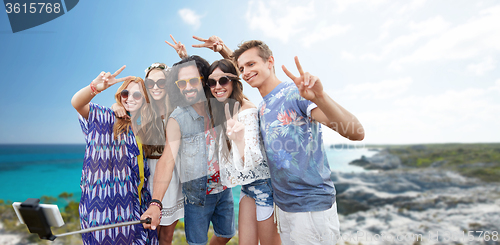 Image of hippie friends with smartphone on selfie stick