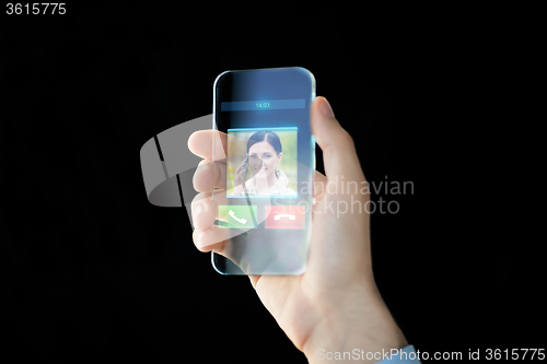 Image of close up of male hand with transparent smartphone