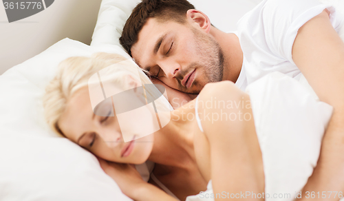 Image of happy couple sleeping in bed at home
