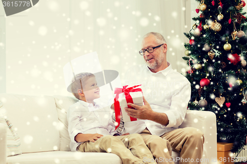 Image of smiling grandfather and grandson at home