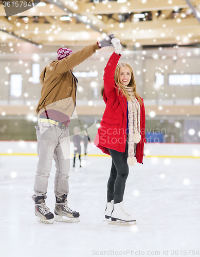 Image of happy couple holding hands on skating rink