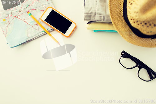 Image of close up of summer clothes and travel map on table