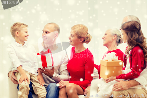Image of smiling family with gifts talking at home