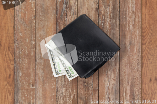 Image of close up of dollar money in black wallet on table