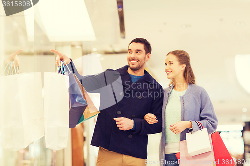 Image of happy young couple with shopping bags in mall