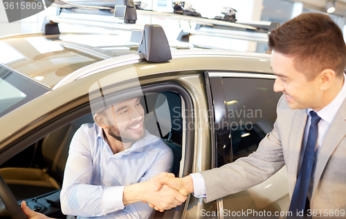 Image of happy man with car dealer in auto show or salon