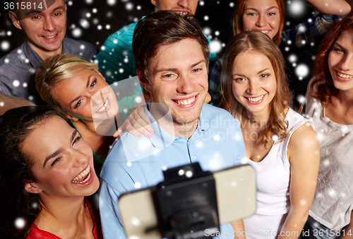 Image of friends with smartphone taking selfie in club