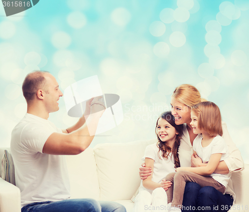 Image of happy family with camera at home