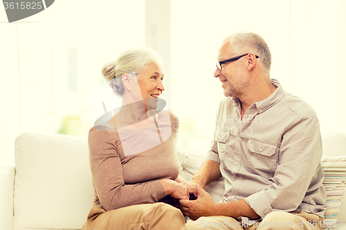 Image of happy senior couple hugging on sofa at home